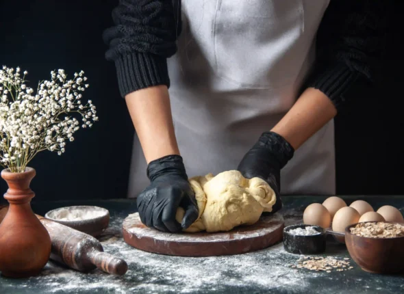 front-view-female-cook-rolling-out-dough-dark-pastry-job-raw-dough-hotcake-bakery-pies-oven-scaled